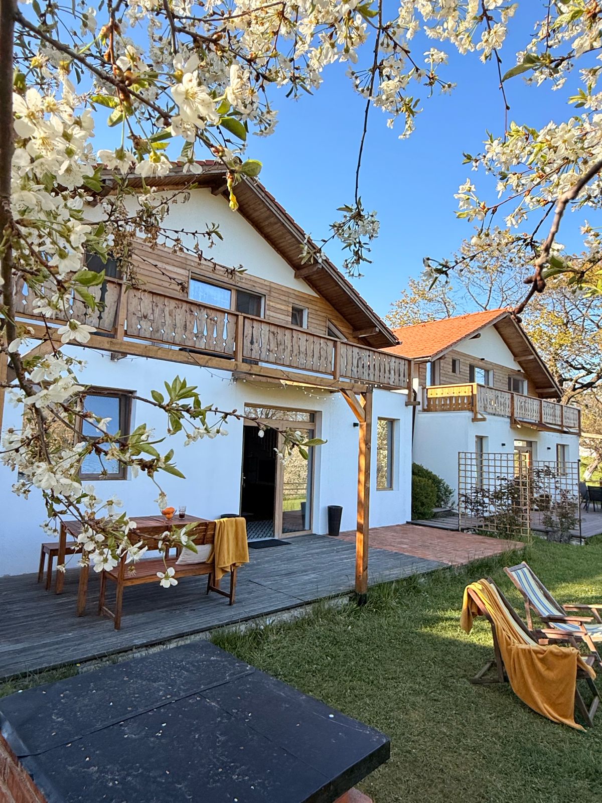 Casa înflorită primăvara, cu terasă și grătar